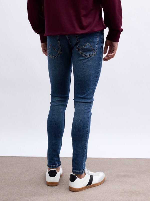 Skinny jeans with rips blue middle back view