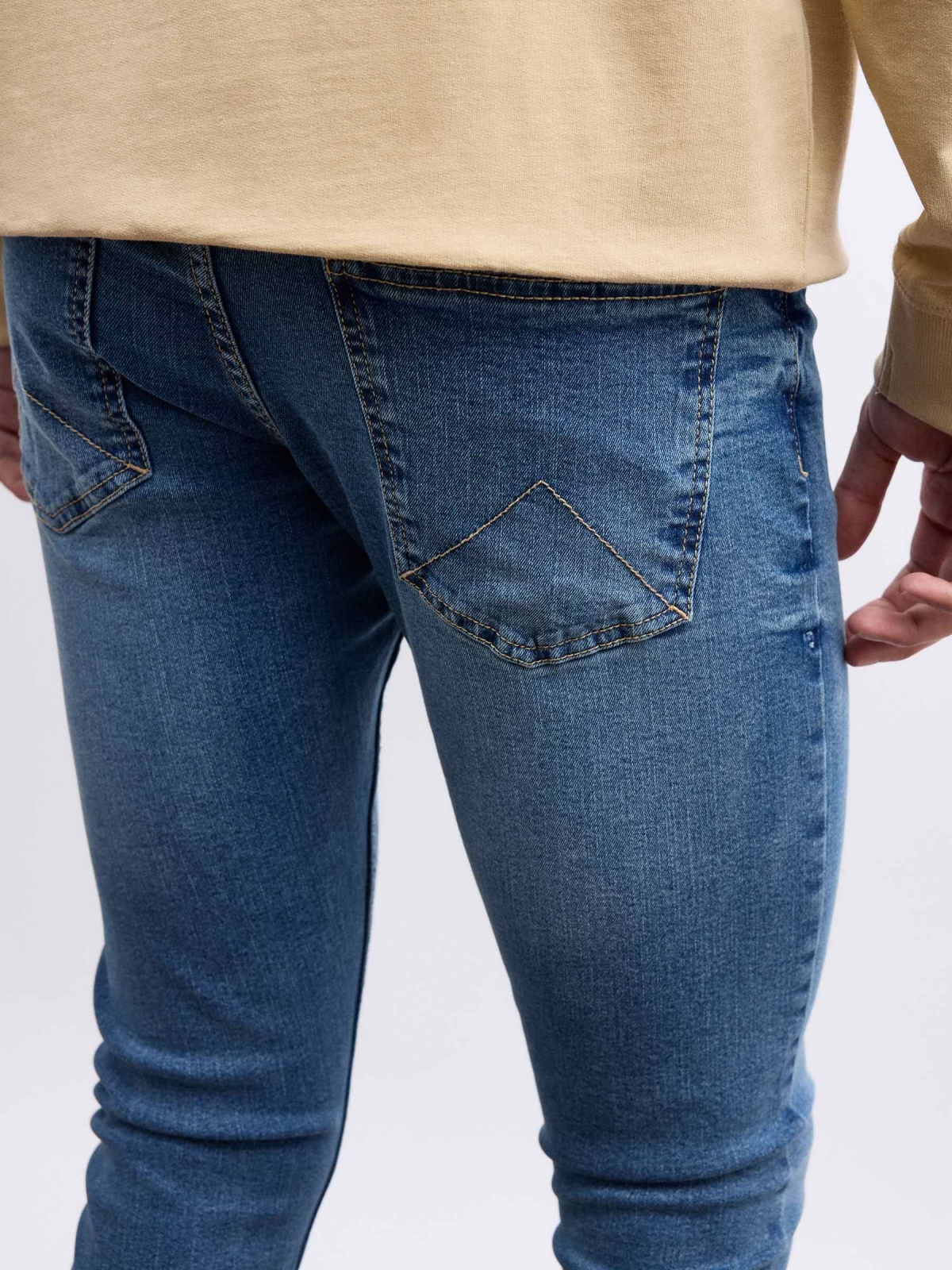 Worn skinny jeans blue detail view