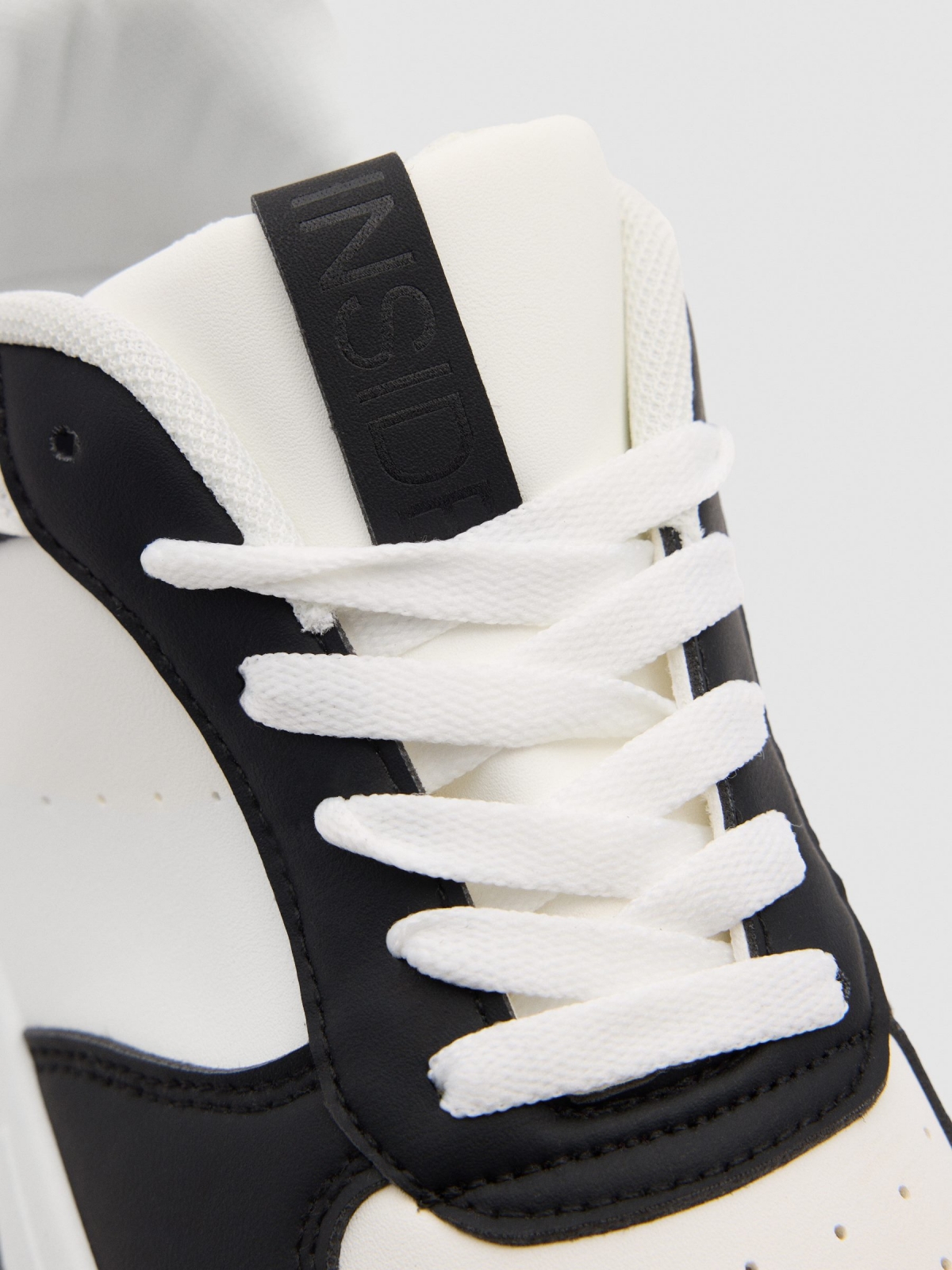 Casual sneakers combined with faux leather white detail view